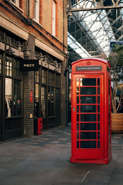 A large, worn and dirty beige garbage bag made of heavy-duty plastic material is positioned on the right side of a narrow, inclined urban street. The bag appears partially open at the top, revealing s