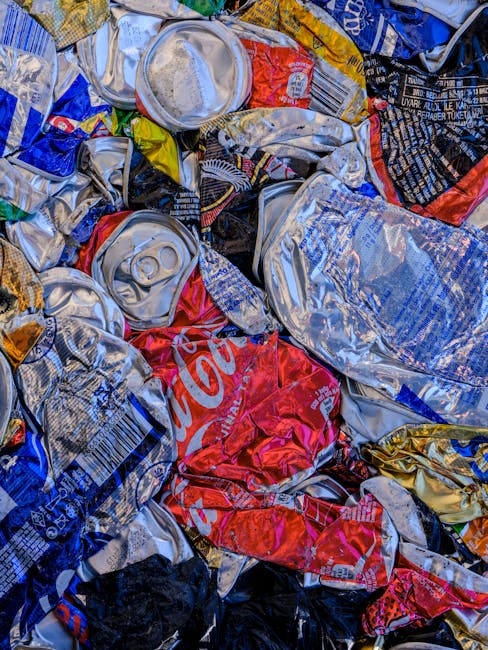 A large collection of transparent plastic rubbish bags filled with mixed waste materials, including clothing, paper, and packaging, is piled on a paved sidewalk in front of a commercial storefront. Be
